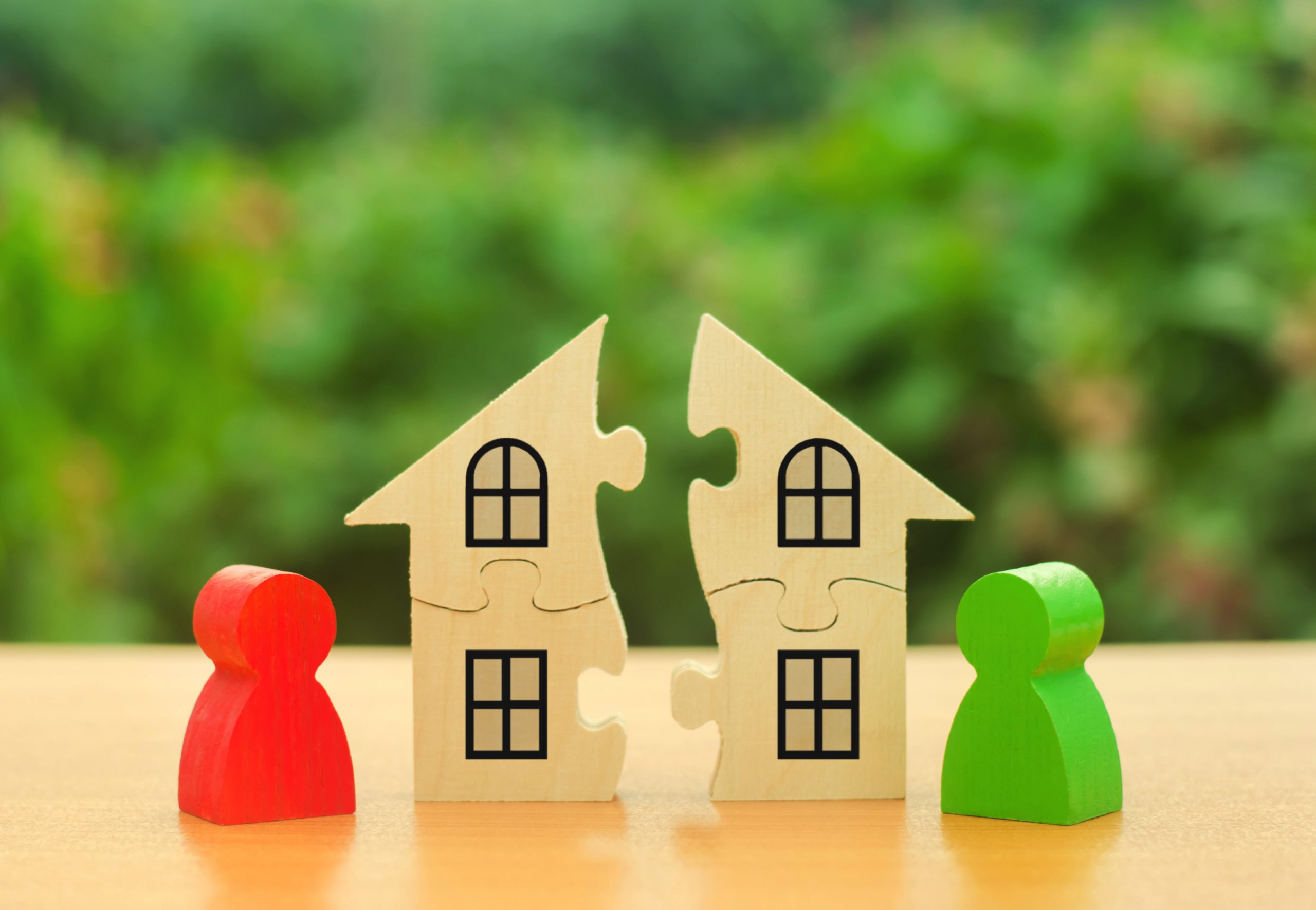 Two human figures divide the house among themselves. Divorce concept. Disputes over division process of real estate and property between former spouses, relatives. Execution of the posthumous will.